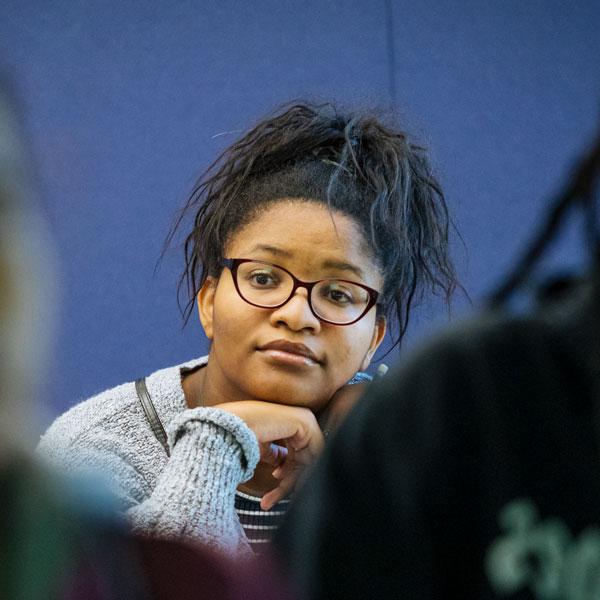 An Agnes Scott student wearing glasses in the mathematics and economics program listens in class.